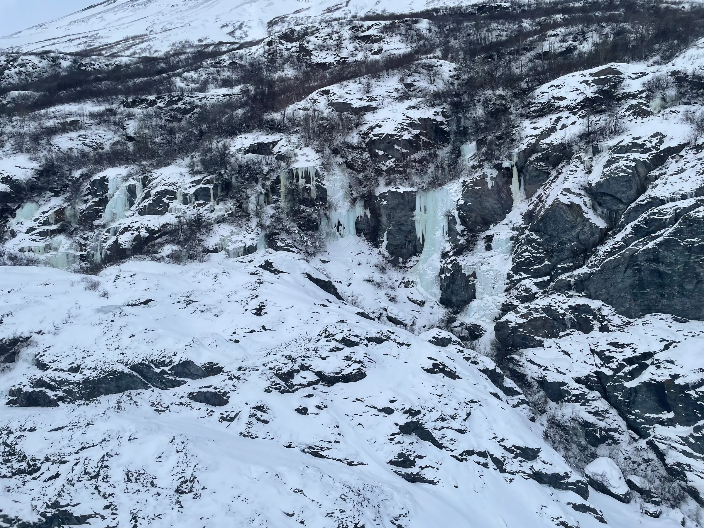覆雪山坡上的冰瀑与岩壁